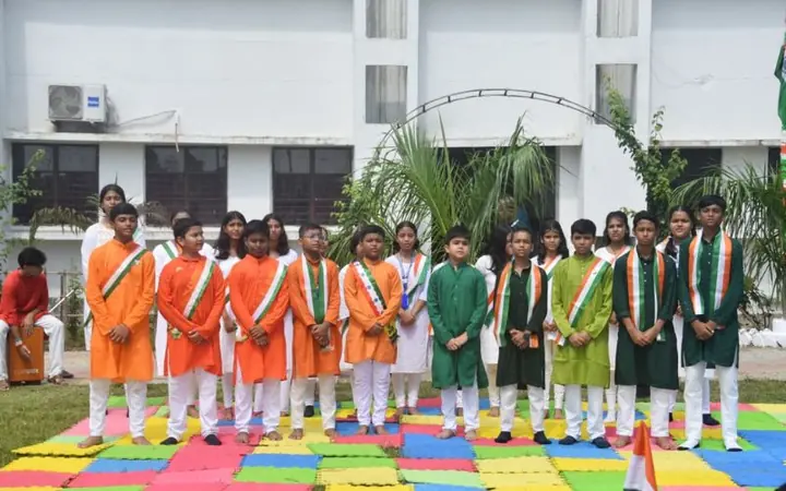 Children of Mount Litera Zee School, Islampur standing together on colourful play mats in the school courtyard