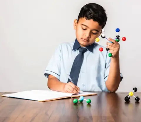 Boy studying with molecule model